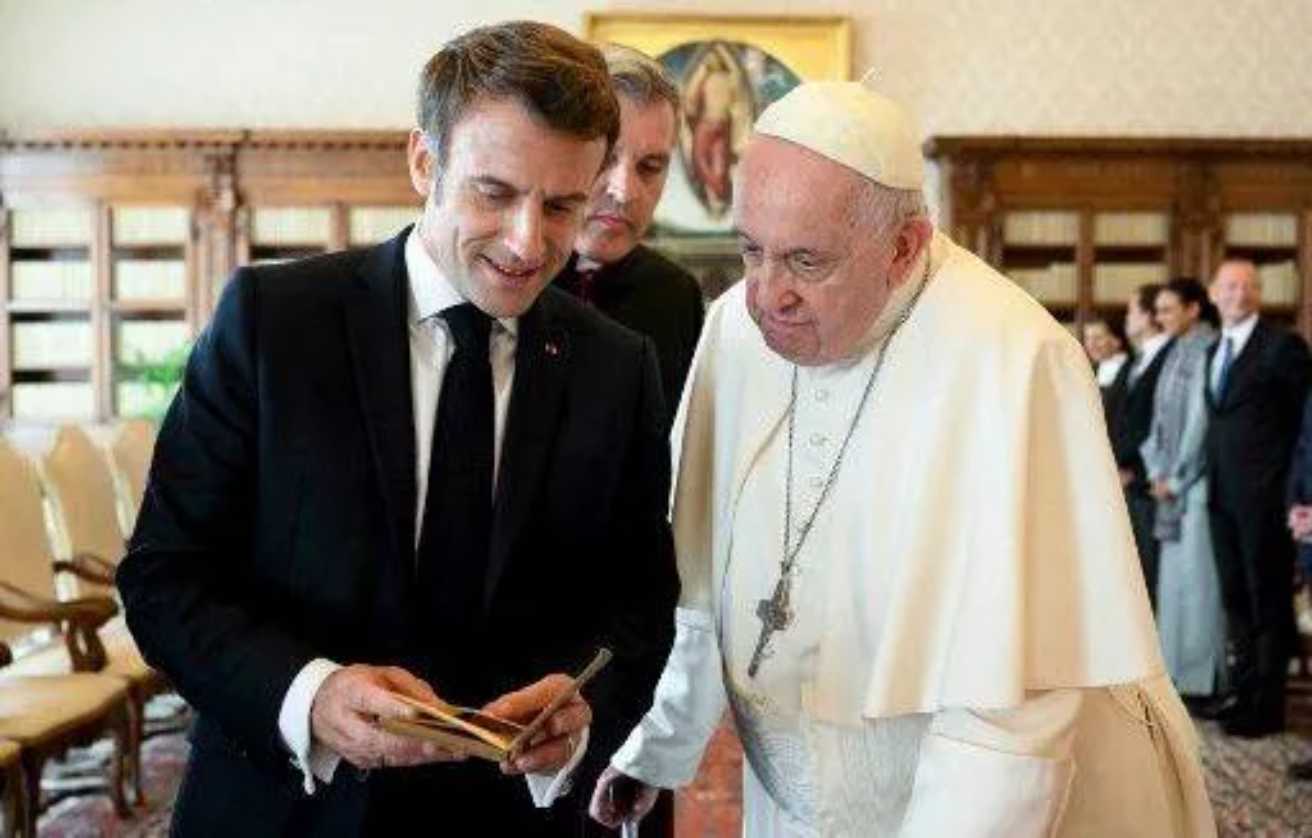 Emmanuel Macron offre au pape François un exemplaire de la première édition en français de l'essai « Projet de paix perpétuelle » d'Emmanuel Kant, le 24 octobre 2022. — VATICAN MEDIA / AFP